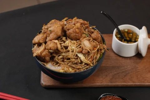 A bowl of noodles with fried chicken and chilli sauce, shot for a Hyderabad restaurant