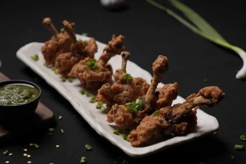 Chicken lollipops plated with green chutney, shot for a Hyderabad restaurant